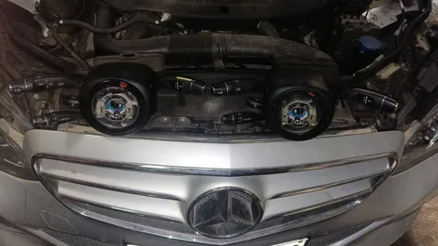 BMW-branded steering-column assemblies photographed beside a Mercedes vehicle