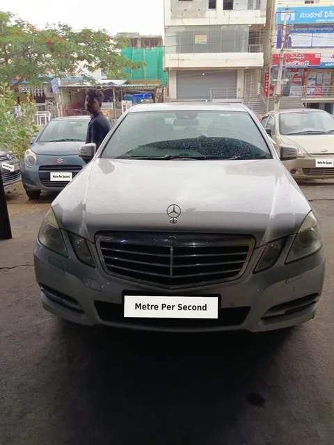 Mercedes-Benz sedan at the workshop entrance with registration plates masked