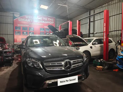 Mercedes-Benz SUV in a repair bay with Metre Per Second branding on the plate