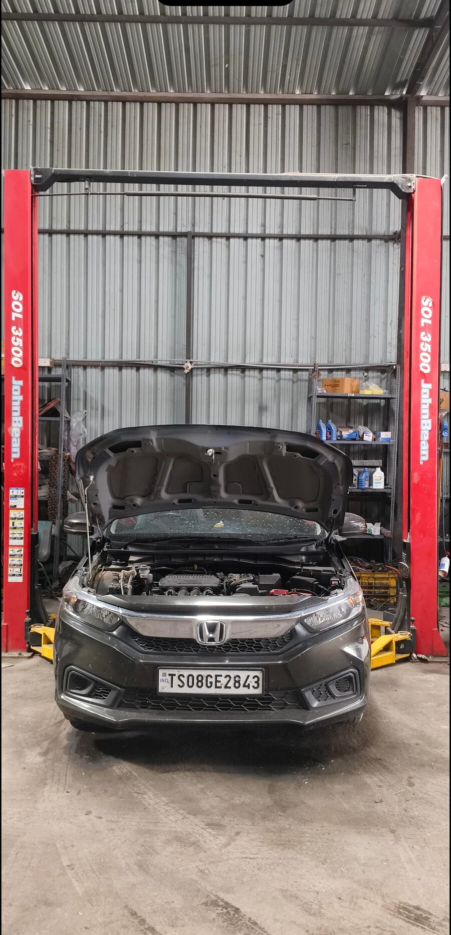 Car on two-post lift for repair at Metre Per Second workshop in KPHB, Hyderabad